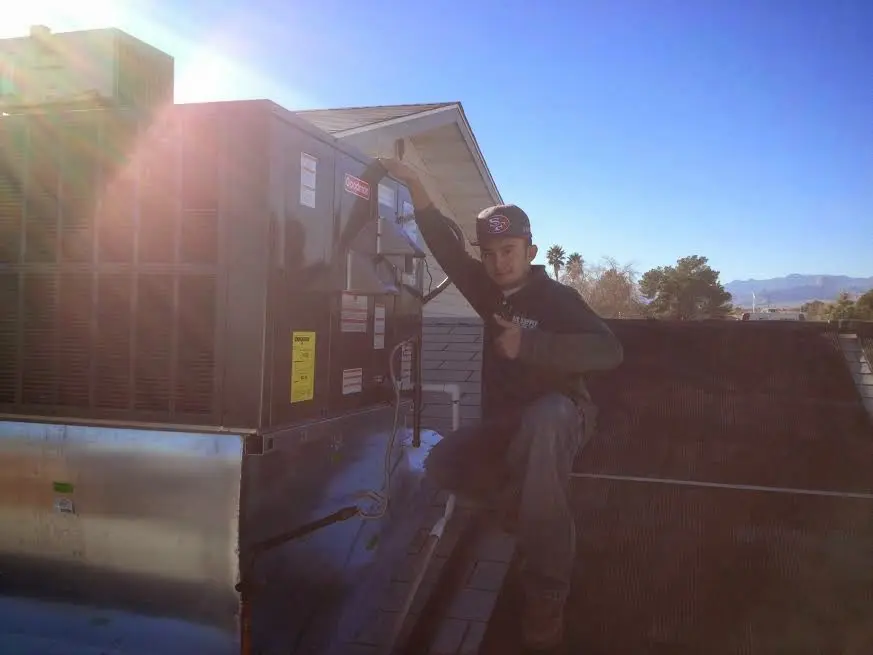 HVAC technician performing AC Tune-Up on a rooftop unit in Oxford
